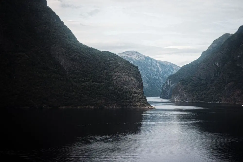Mektig fjord i vestlandsnatur med stille vann og stupbratte fjell