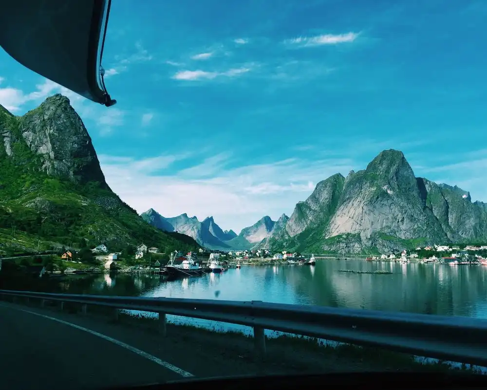Fjell speiler seg i blikkstille vann i Vågan, Lofoten