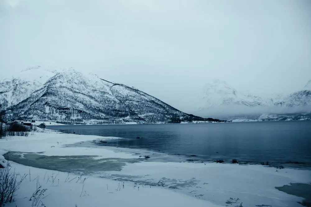 Snødekte fjell og frossen innsjø i Troms om vinteren
