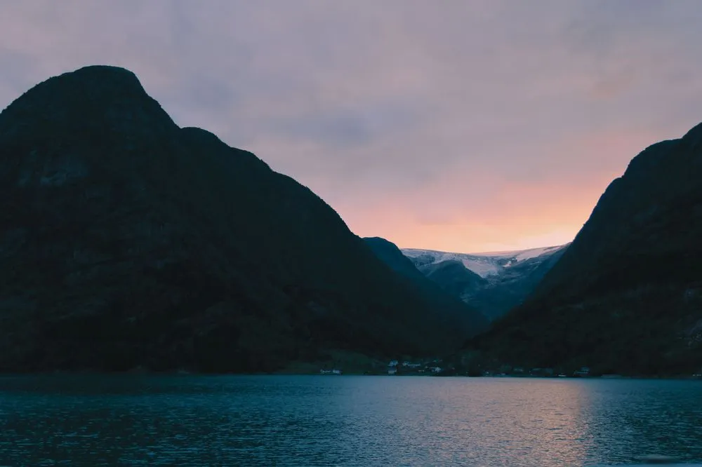Norsk fjordlandskap i kveldslys med høye fjellsider